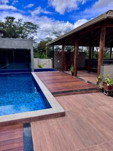 a swimming pool with a wooden deck and a pavilion at Sítio Recanto da Serra in Mateus Leme +11 photos