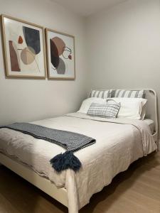 a bedroom with a bed with two pictures on the wall at A Gentle Hideaway in the Urban Forest WEST END downtown Vancouver in Vancouver