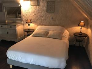 una camera con un letto bianco e due tavoli con lampade di Gîte dans une écurie rénovée avec jardin privé, clim, parking et WIFI - FR-1-510-150 a Flines-lès-Mortagne