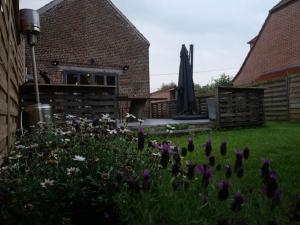 un giardino con fiori viola nel cortile di Gîte dans une écurie rénovée avec jardin privé, clim, parking et WIFI - FR-1-510-150 a Flines-lès-Mortagne