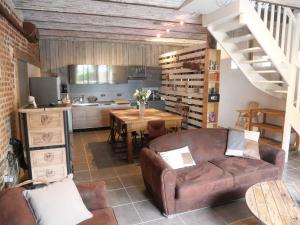 un soggiorno con un divano e un tavolo di Gîte dans une écurie rénovée avec jardin privé, clim, parking et WIFI - FR-1-510-150 a Flines-lès-Mortagne