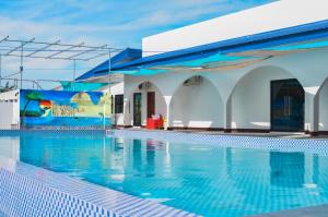 a swimming pool with a blue and white building at Pebble Peninsula Resort in San Francisco