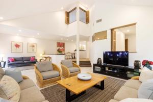 a living room with a couch and a tv at Mirage Resort Villa 409 with access to Sheraton Facilities in Port Douglas