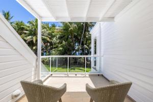 an empty porch with two chairs and a large window at Mirage Resort Villa 409 with access to Sheraton Facilities in Port Douglas