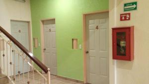 un pasillo con paredes verdes y puertas blancas en Hotel Astur, en Guadalajara