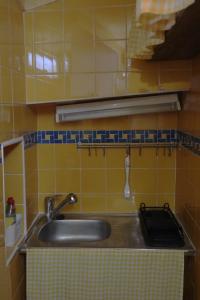 a sink in a kitchen with yellow tiles at Casa da Porta da Vila in Nisa +8 photos