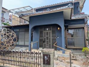 别府地獄の三丁目 鬼のすみか的前面有栅栏的蓝色房子