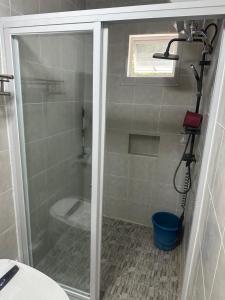 une douche avec une porte vitrée dans une salle de bain dans l'établissement Farm small courtyard, à Sampong 7 autres photos