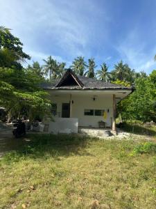 une maison blanche avec des palmiers en arrière-plan dans l'établissement Farm small courtyard, à Sampong