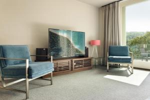 a living room with two chairs and a flat screen tv at Take Five in Ambleside