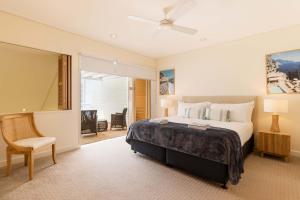 a bedroom with a large bed and a chair at Mirage Resort Villa 438 with access to Sheraton Facilities in Port Douglas