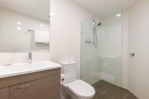a bathroom with a toilet and a glass shower at Mirage Resort Villa 438 with access to Sheraton Facilities in Port Douglas