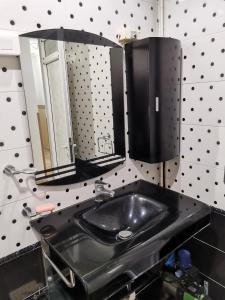 a bathroom with a black sink and a mirror at Djawed hôt in Alger