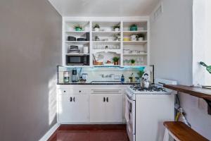 Una cocina con gabinetes blancos y un horno de estufa. en Springtime Oasis Sun Kised 1BR Near UofA, en Tucson