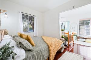 1 dormitorio con 1 cama con paredes y ventanas blancas en Springtime Oasis Sun Kised 1BR Near UofA, en Tucson