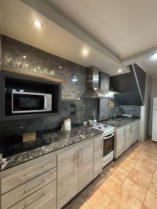 a kitchen with a stove and a microwave at Casa Familiar in San Rafael