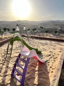 a chair sitting in the sand on a beach at Tuscany Villa Jarash in Al Madwar