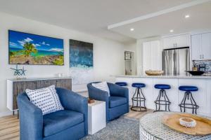 a living room with two blue chairs and a kitchen at KIHEI SURFSIDE, #501 condo in Wailea +44 photos