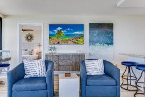 a living room with two blue chairs and a table at KIHEI SURFSIDE, #501 condo in Wailea