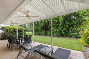 a white pergola on a patio with tables and chairs at Mirage Resort Villa 456 with access to Sheraton Facilities in Port Douglas