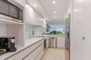 a large white kitchen with white counters and appliances at Mirage Resort Villa 456 with access to Sheraton Facilities in Port Douglas