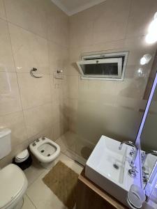 a bathroom with a toilet and a sink at Casa Familiar in San Rafael +15 photos