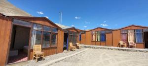 una fila di cabine di legno con sedie e tavoli di Khayoul Cottage Pangong Lukung a Spangmik