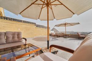 a patio with a couch and an umbrella at Pyramids Secret Hotel in Cairo