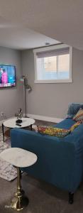 艾尔德里Immaculate suite in Airdrie的客厅里有一张蓝色沙发和一台电视