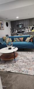 艾尔德里Immaculate suite in Airdrie的客厅里有一张蓝色的沙发和一张桌子