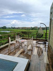 a patio with two chairs and a hammock on a balcony at Golf Villa Vedic Village in kolkata
