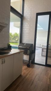 eine Küche mit einer großen Tür, die auf eine Terrasse führt in der Unterkunft Orchid Boutique Chalet in Barka