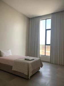 a bedroom with a bed and a large window at Orchid Boutique Chalet in Barka +34 photos