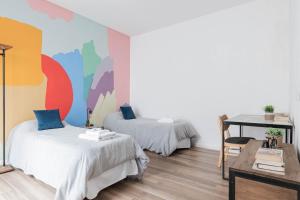 Cette chambre comprend 2 lits, une table et un mur. dans l'établissement Fliphaus Villa Honduras 5700 - Lux 5 Bd Gastronomic Area Daily Housekeeping!, à Buenos Aires