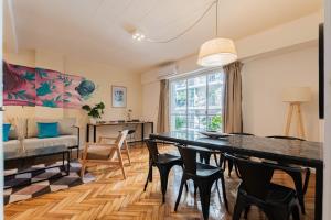 Una sala de estar con una mesa y sillas y un sofá. en Fliphaus Junin 1200 - 2 Bd in Recoleta, en Buenos Aires 8 fotos más