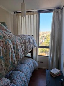 a bedroom with two beds and a large window at Departamento de Lina in Valparaíso