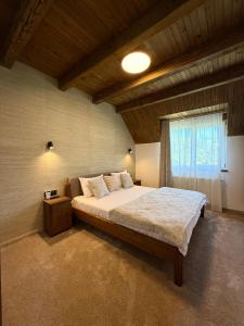 a bedroom with a large bed and a window at Bradutul de la munte Chalet in Braşov