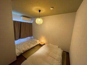 Ένα ή περισσότερα κρεβάτια σε δωμάτιο στο 島めぐりに便利な一棟貸切宿あぽわん