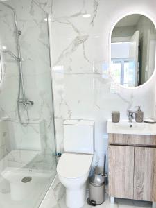 a white bathroom with a toilet and a shower at Figueira Luxury Comfort House in Figueira da Foz