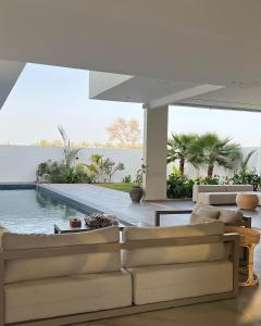 ein Wohnzimmer mit Couch und Swimmingpool in der Unterkunft Orchid Boutique Chalet in Barka