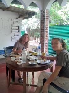 un uomo e una donna seduti a un tavolo con del cibo di Sigiriya Lions Rest Hostel a Sigiriya