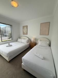 two beds sitting next to each other in a room at Discover Cronulla - Beach Escape in Cronulla