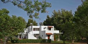 a white house with trees in front of it at Eretria Park Studios in Eretria