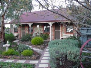 a brick house with a bench in front of it at Langmeil Cottages in Tanunda