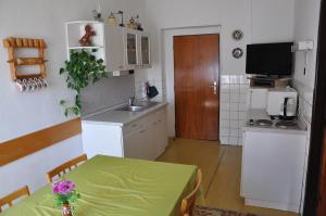 a kitchen with a table with a green table cloth at Penzion Hainiš in Janske Lazne