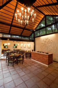 a restaurant with tables and a chandelier in a room at Vivanta Bengaluru Residency Road in Bangalore