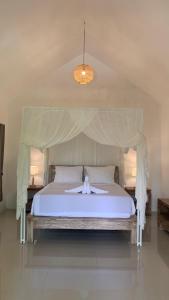 una camera da letto con un letto bianco con baldacchino di Mayong Bali Villa and Hostel a Munduk