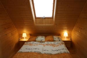 ein Schlafzimmer mit einem Bett in einer Holzhütte in der Unterkunft Domek z Bala Pod Żaglami in Pobierowo