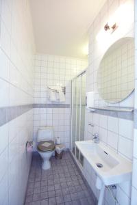 a white bathroom with a toilet and a sink at Lages Motel in Borås