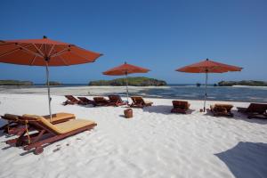 a group of chairs and umbrellas on a beach at Seven Islands Resort in Watamu